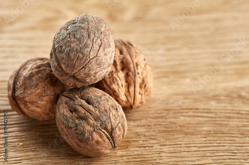 A stack of hard shells of walnuts piled together on light grey fabric cotton tablecloth, selective focus