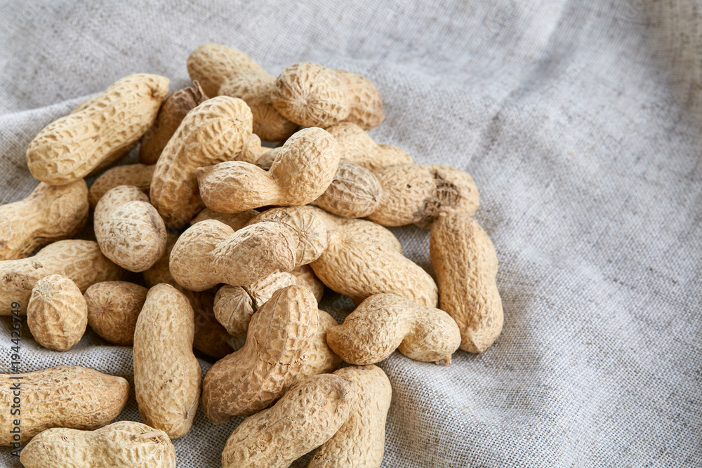 Heap of peanuts on light tablecloth, close-up, shallow depth of field, selective focus, macro Heap of peanuts on light tablecloth, close-up, shallow depth of field, selective focus, macro