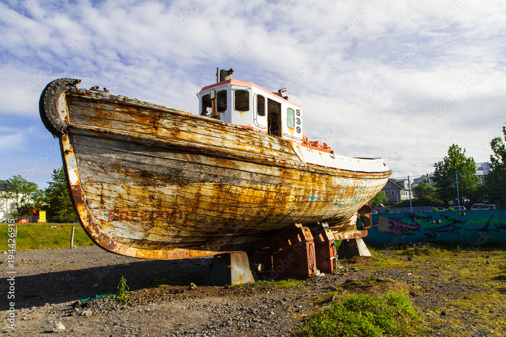 Old boat on the volcanic field is a side view. Iceland