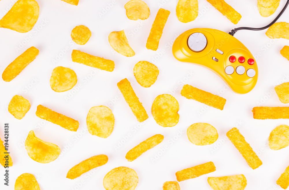 Yellow joystick and potato chips. Harmful food and gamepad. GamePad. Yellow joystick and potato chips. Harmful food and gamepad. GamePad.