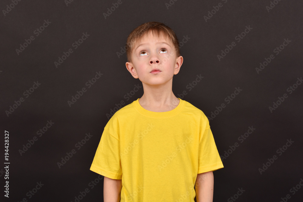 Portrait of a boy on a black background.Friend in a yellow T-shirt.