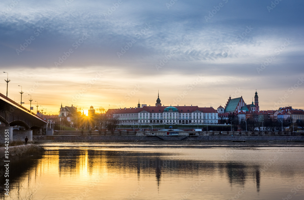 Sunset over the Royal castle and old town on the other side of  Vistula river in Warsaw, Poland