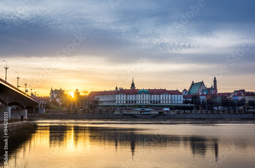 Sunset over the Royal castle and old town on the other side of Vistula river in Warsaw, Poland