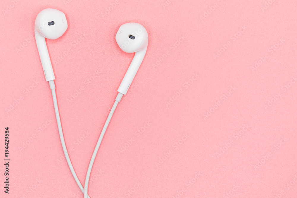 Top view Lovely Closeup of White Earphones on Pink Pastel plastic texture background. Pastel color concept, Minimal concept. Copy space. Music is my life concept. Valentine concept Top view Lovely Closeup of White Earphones on Pink Pastel plastic texture background. Pastel color concept, Minimal concept. Copy space. Music is my life concept. Valentine concept