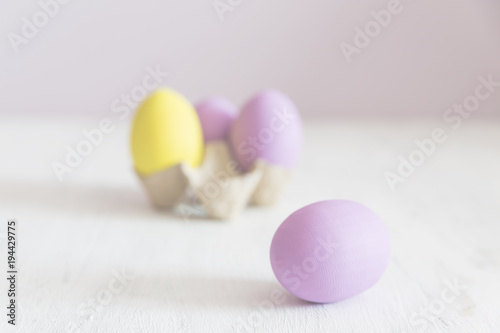 Easter postcard. Violet and yellow Easter eggs on a white vintage background. Copy space.