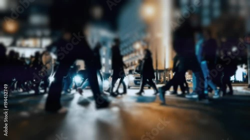 An anonymous crowd of pedestrians walking and crossing a busy city street. No logos, faces visible. Commercial shot.