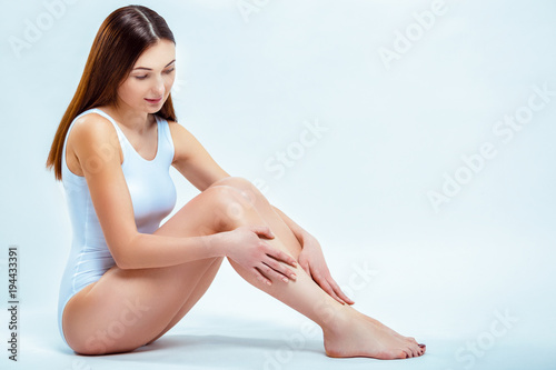 Portrait of a beautiful young woman with long slender legs. Depilation