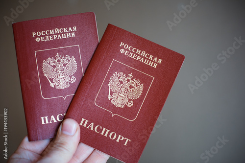 Two russian passports in hand. Russian official document on black background