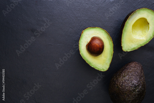 Avocado half on dark background Fototapet