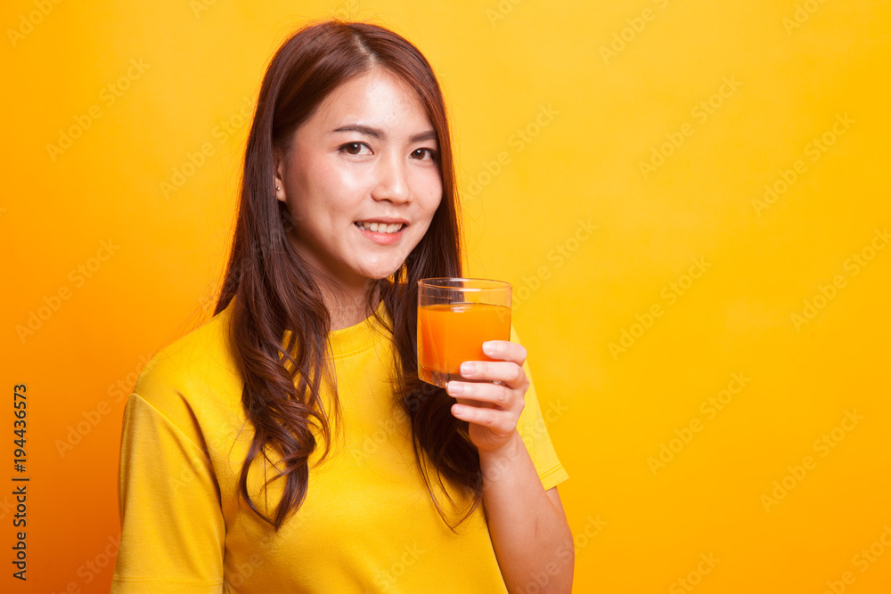 Young Asian woman drink orange juice in yellow dress Young Asian woman drink orange juice in yellow dress