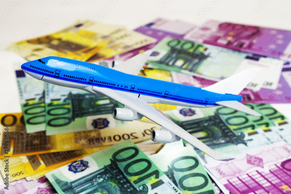 Blue white airplane on dollar and euro in cash close-up. Financial concept. tourist concept.