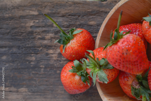 Close up of fresh delicious strawberries in wooden bowl.