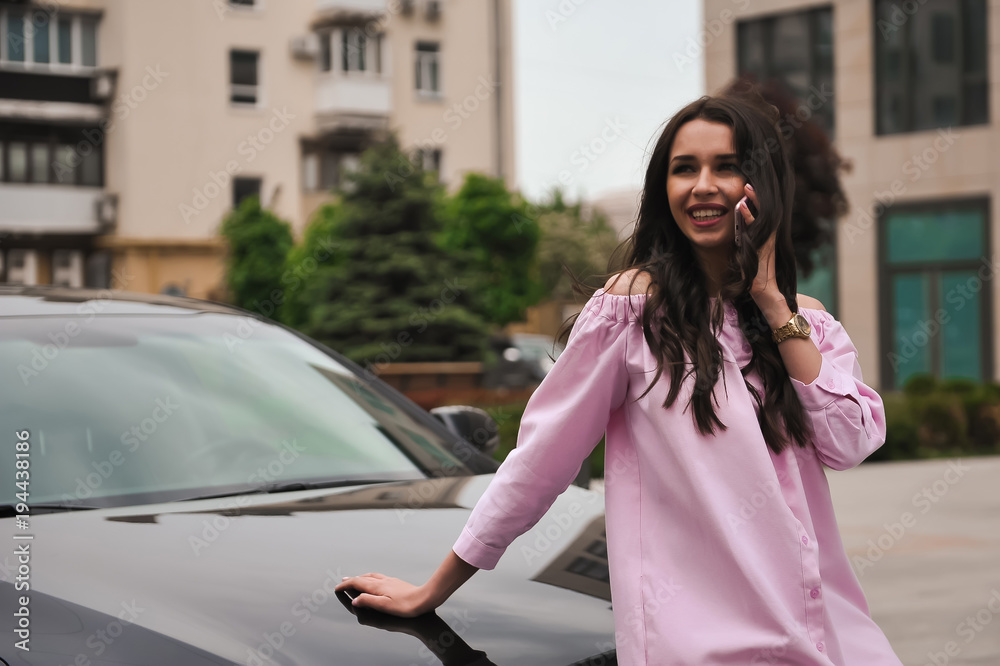 woman standing near car and calling by phone