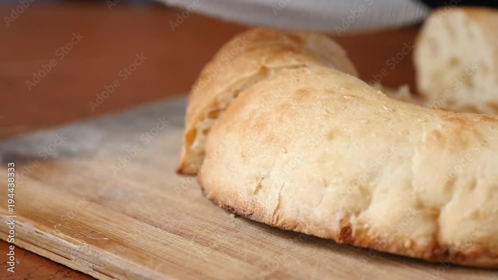 sliced white bread on the kitchen cutting board. Soft freshly baked white bread. slow motion sliced white bread on the kitchen cutting board. Soft freshly baked white bread. slow motion