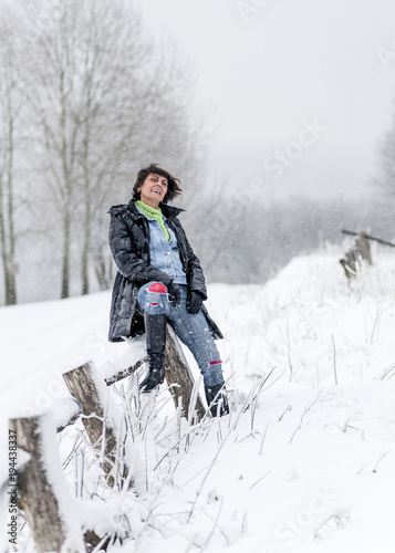 Portrait of  happy, middle age woman on winter landscape