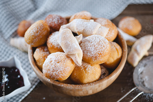 Homemade sweet dessert pastry covered by icing sugar in a wooden bowl