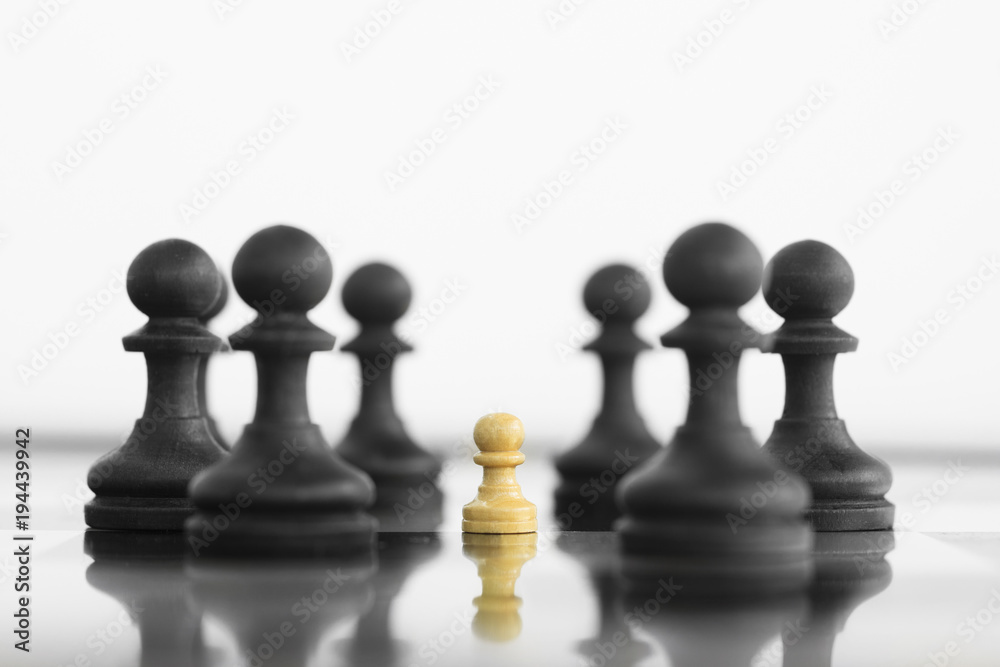 Self confidence white peon standing in front of a black chess army before confrontation Self confidence white peon standing in front of a black chess army before confrontation