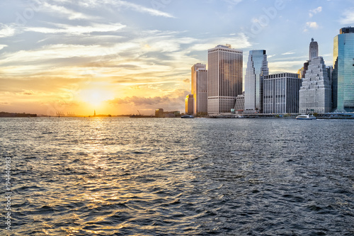 View of outside outdoors in NYC New York City Brooklyn Bridge Park by east river, cityscape skyline during sunset, statue of liberty