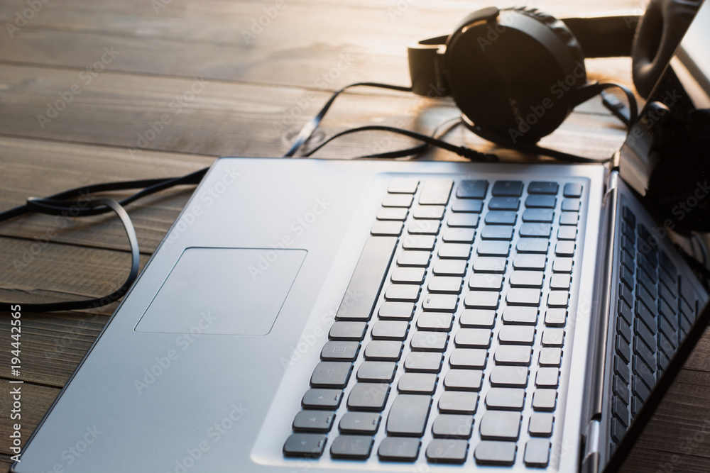 Headphones and laptop keyboard on wooden board. Headphones and laptop keyboard on wooden board.