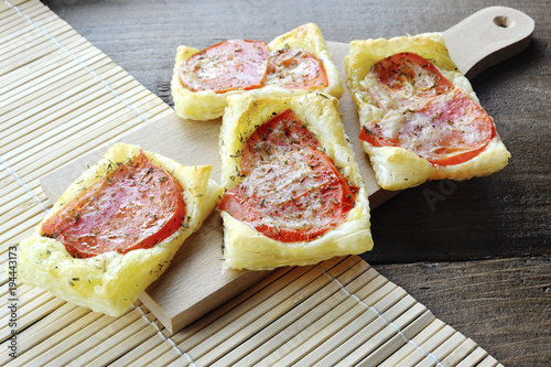 Tasty puff pastry pizzas with tomatoes and origan