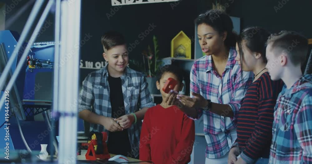 Black teacher with group of children having class about three dimensional technologies. Movement 4K shot on Red cinema camera.