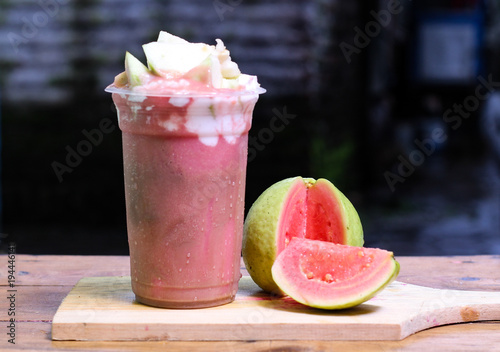 Milkshake with guava pieces, in  plastic cup, delicious and fresh.