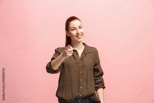 The happy business woman point you and want you, half length closeup portrait on pink background.