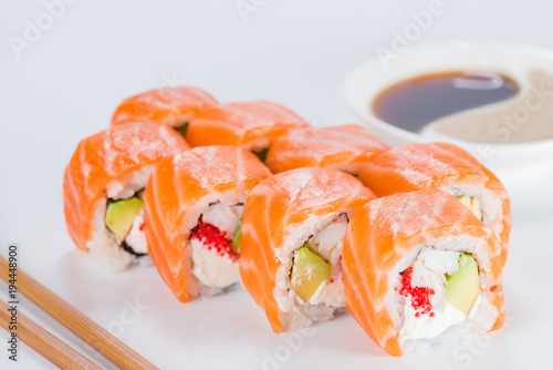 Delicious Philadelphia sushi rolls with rice, avocado, caviar, cream cheese and salmon on light background