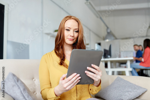 redhead woman with tablet pc working at office