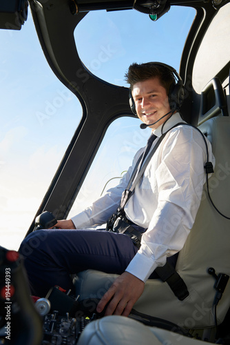 Portrait Of Pilot In Cockpit Of Helicopter During Flight