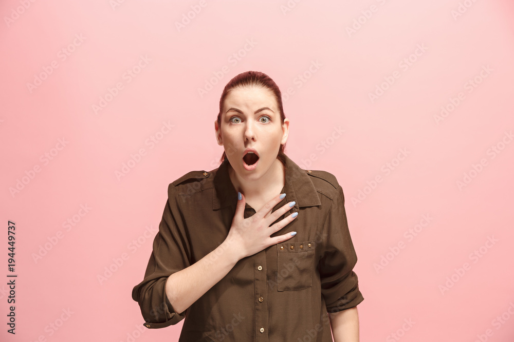 Beautiful woman looking suprised isolated on pink