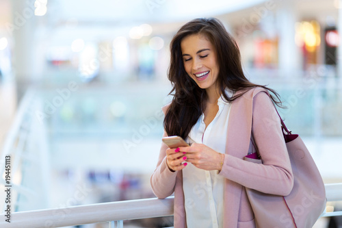 Woman using mobile phone in shopping mall 