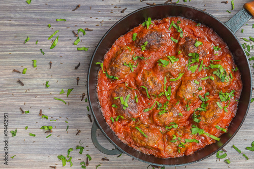 Greek soutzoukakia the patties in tomato sauce in the pan. Close up. The view from the top. Copy-space.