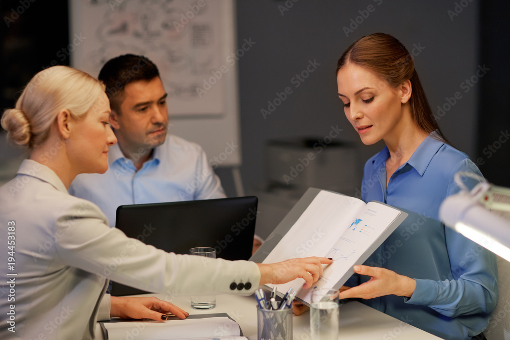 business team with papers working at night office