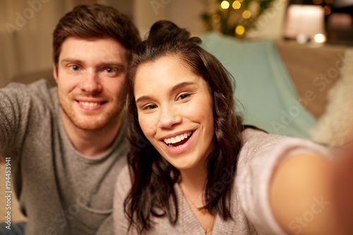 happy couple taking selfie at home