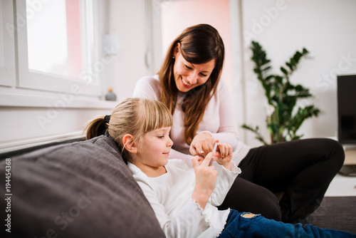 Mother and daughter playing games on smartphone.