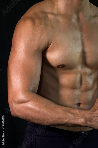 Close up bodybuilder muscular beautiful body on black background