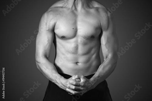 Close up bodybuilder muscular beautiful body on black and white with gray background