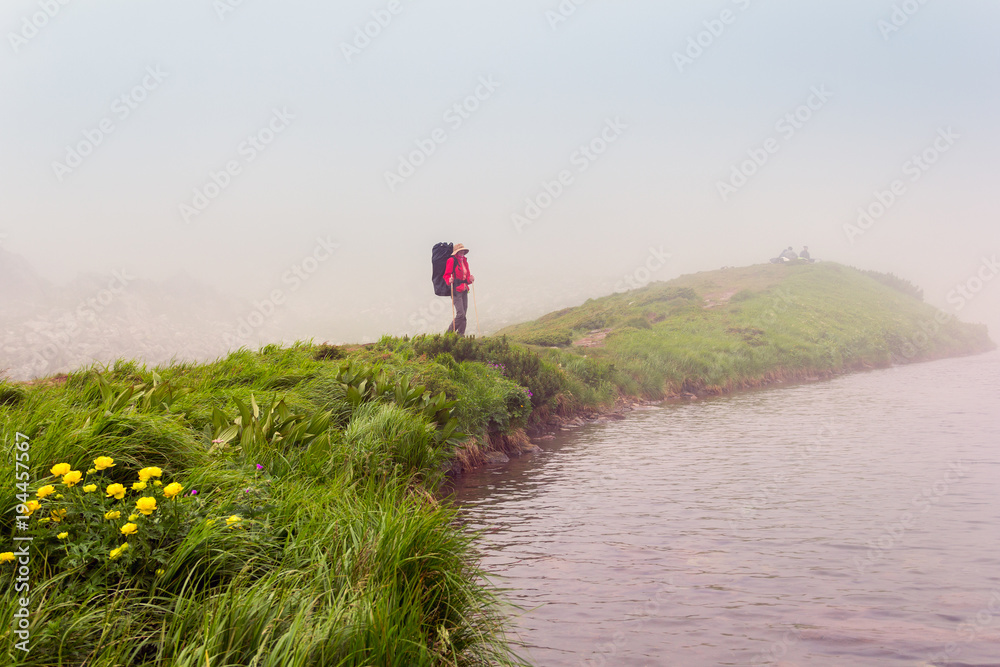 a lonely girl with a backpack is standing by the lakeshore a lonely girl with a backpack is standing by the lakeshore