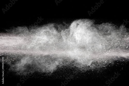 Launched white particle splash on black background. Bizarre forms of of white powder explosion cloud against dark background.