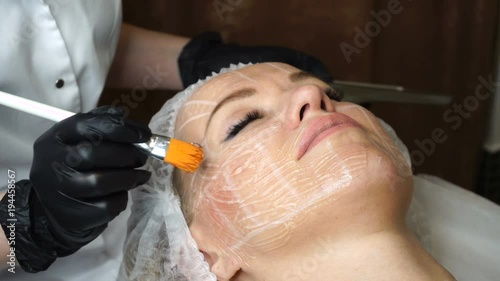 Non-surgical face lifting. Lubrication lifting ultrasonic. Facelift. Process of rejuvenation. Spa treatment. Hardware cosmetology. Beautician application of conductive gel to skin photo