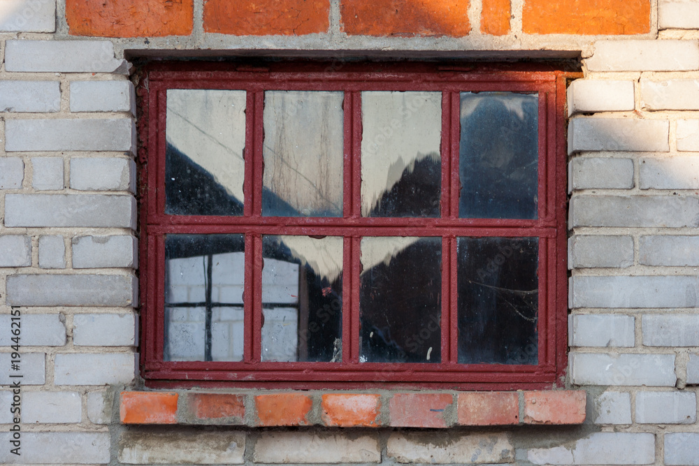 Obraz premium Old red window on a white brick wall