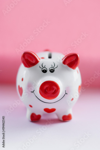 Savings concept. Funny piggy bank and on pink background