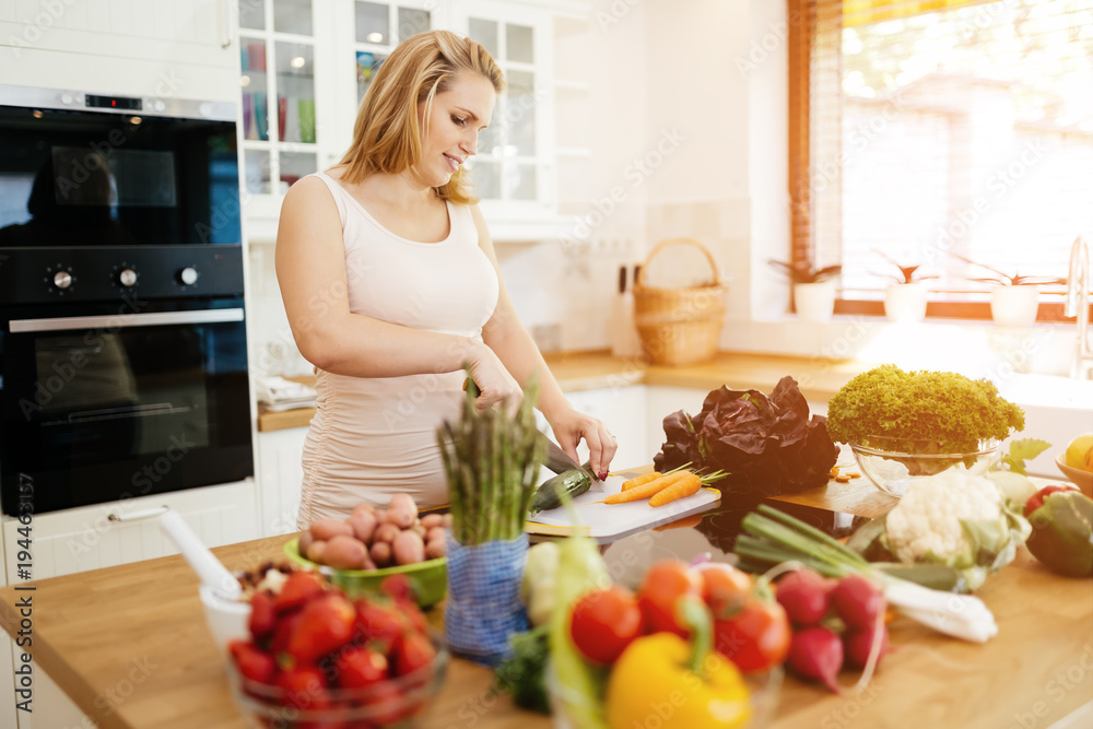 Pregnant woman making a meal in kitchen Pregnant woman making a meal in kitchen