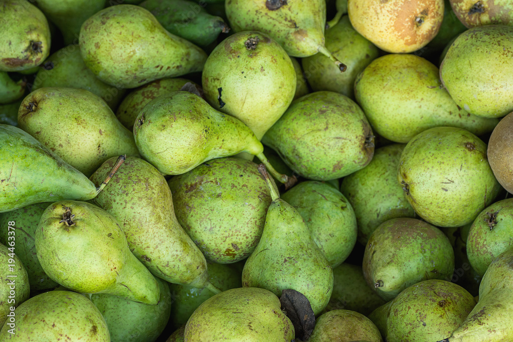 Heap of Ripe Organic Green Pears in Wooden Box at Farmers Market. Bright Vibrant Colors. Vitamins Superfoods Healthy Diet Harvest Concept. Sunlight Summer Mood. Close up Heap of Ripe Organic Green Pears in Wooden Box at Farmers Market. Bright Vibrant Colors. Vitamins Superfoods Healthy Diet Harvest Concept. Sunlight Summer Mood. Close up