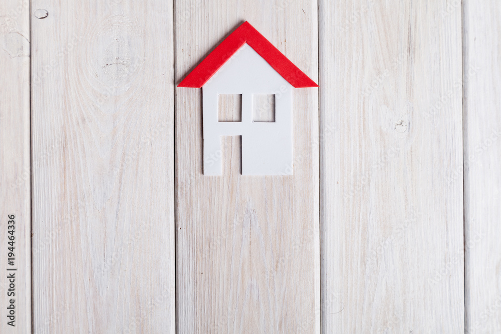 Small house with key over white wood an white background. Small house with key over white wood an white background.