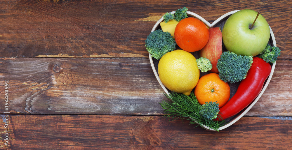 Fruits and Vegetables in Heart shaped Wooden Box. Broccoli, apples, Pepper, tangerine over Wooden Background. Banner. Health food Concept with copy space. Fruits and Vegetables in Heart shaped Wooden Box. Broccoli, apples, Pepper, tangerine over Wooden Background. Banner. Health food Concept with copy space.