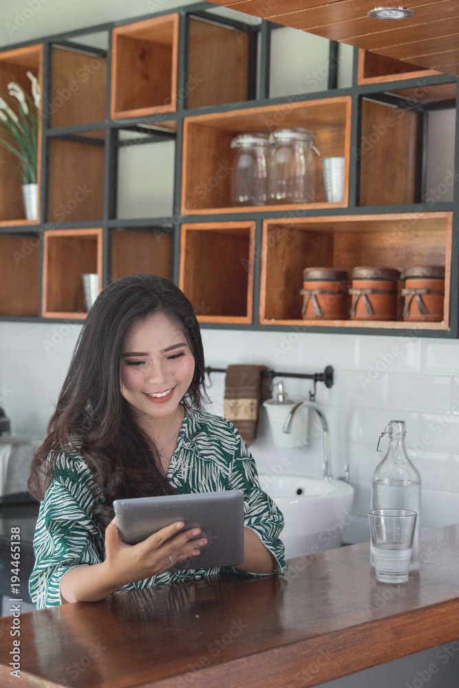 woman using tablet in kitchen woman using tablet in kitchen