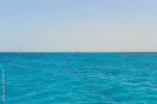Ship on the horizon of the blue sea