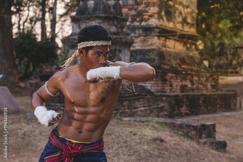 Ancient Muay Thai, Asian man exercising thai boxing,Ancient traditional Muay Thai or Thai boxing fighter putting bandage old style at Thailand.